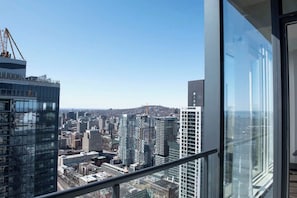 A high-rise building with a view of a cityscape, including other tall buildings and a construction crane. - Rare luxury penthouse/P5 Executive Collection (Montréal)
