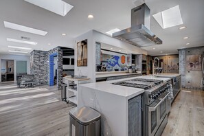 A modern kitchen with a central island, built-in ovens, and a large window above the island. - 10BD/10BA Contemporary Japanese Villa (Las Vegas)