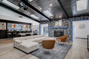 A modern living room with a sectional sofa, a fireplace, and a dining area with a kitchen in the background. - 10BD/10BA Contemporary Japanese Villa (Las Vegas)