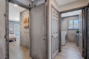 A modern interior with a large mirror, a laundry area, and a bedroom with a bed and a nightstand. - 10BD/10BA Contemporary Japanese Villa (Las Vegas)