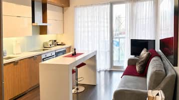 A modern apartment with a kitchen, dining area, and living room.