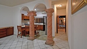 A kitchen with a dining area, featuring a central island, wooden chairs, and a tiled floor. - Single-story house with a private pool, within walking distance of the beach (La paz)