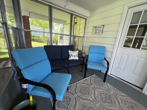 A porch with a blue sofa and chairs, a patterned rug, and a sign that reads 'Memories.' - Vintage Charm Near Pilot Mountain and Mount Airy (Westfield)