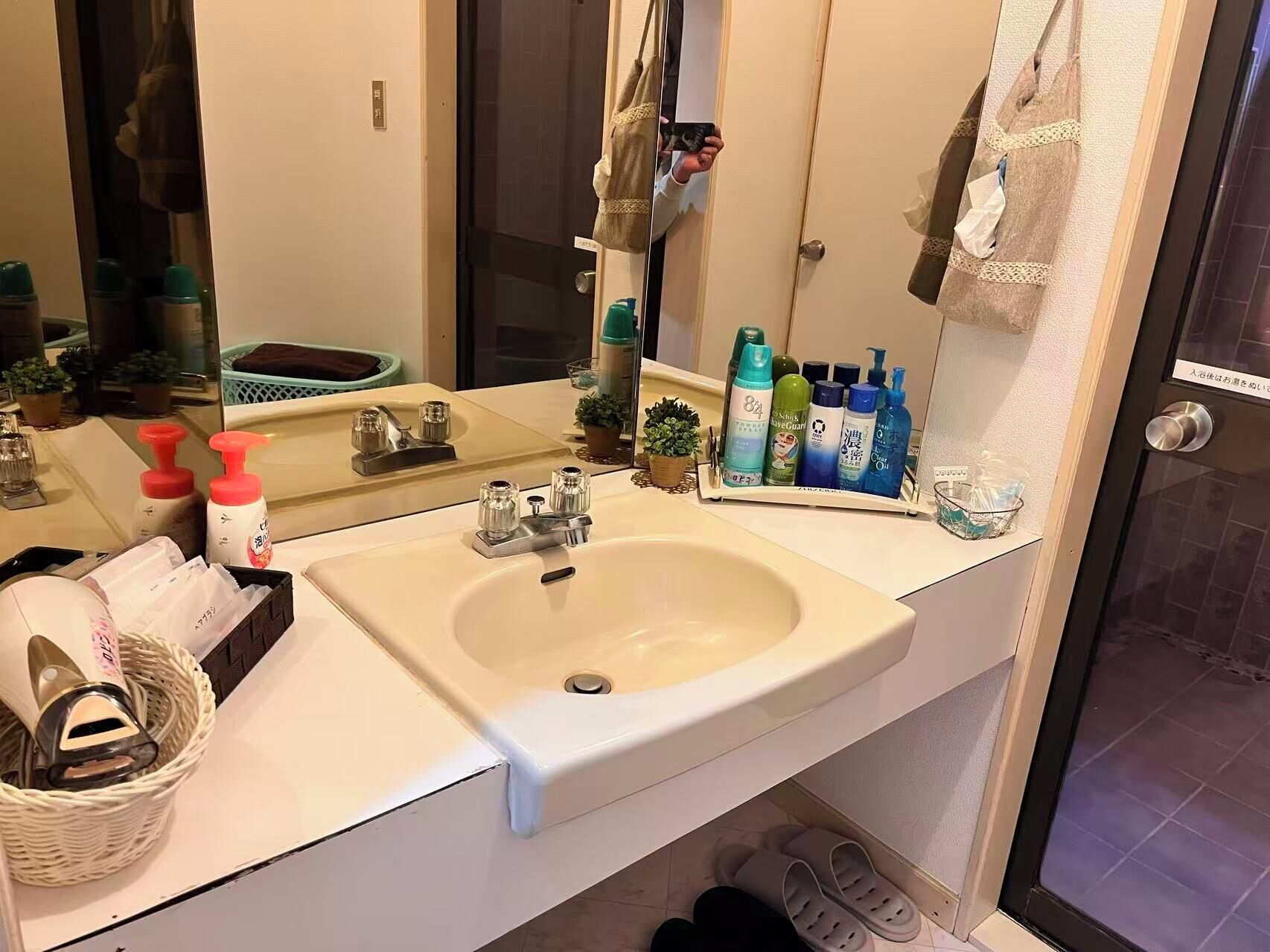 A bathroom with a sink, mirror, and various toiletries.