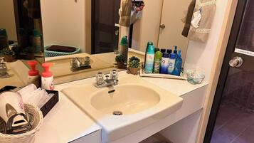 A bathroom with a sink, mirror, and various toiletries.