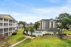 A residential complex with multiple apartment buildings, a swimming pool, and well-maintained lawns. - Ocean Keyes 3BR First Floor Condo - North Myrtle Beach (North Myrtle Beach)