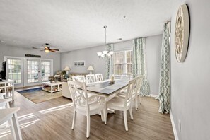 A dining area with a table and chairs, a ceiling fan, and a chandelier. - Ocean Keyes 3BR First Floor Condo - North Myrtle Beach (North Myrtle Beach)