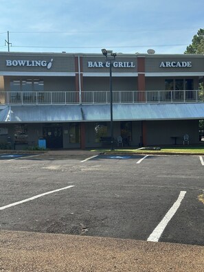 Un edificio con bolera, bar y parrilla, y sala de juegos en la planta baja.
