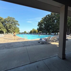 Un área de piscina con sillones de descanso y cielo despejado.