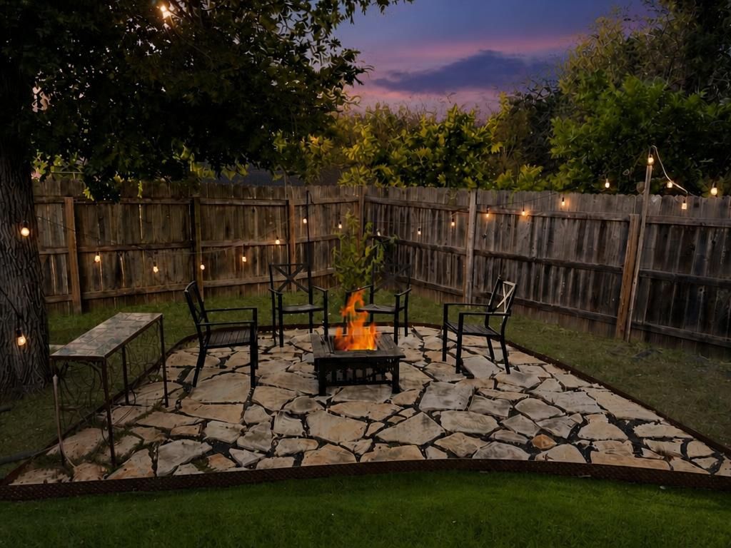 Un patio al aire libre con piso de piedra, un hoyo de fuego y mobiliario exterior.