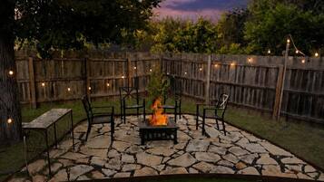 An outdoor patio with stone flooring, a fire pit, and outdoor furniture.