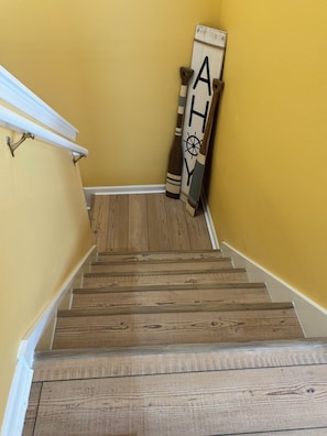A wooden staircase with a white handrail and a yellow wall. - Welcome to "The Coastal Beach Villa"- Your Seaside Retreat in Gulfport, MS! (Gulfport)
