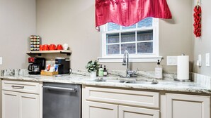 A kitchen with a dishwasher, a coffee maker, and a sink. - NEW! Kid Friendly 3BR Fenced Yard - Sports Complex (Youngsville)