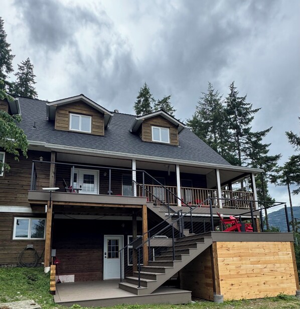 A two-story house with a balcony, a covered porch, and a staircase leading to the upper level.
