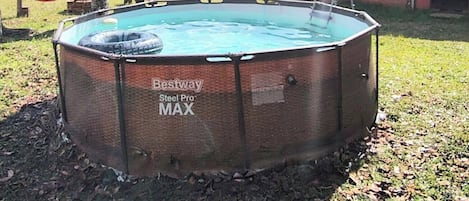 Un patio trasero con un jacuzzi identificado como 'Beastway Steel Pro MAX' y una hamaca.