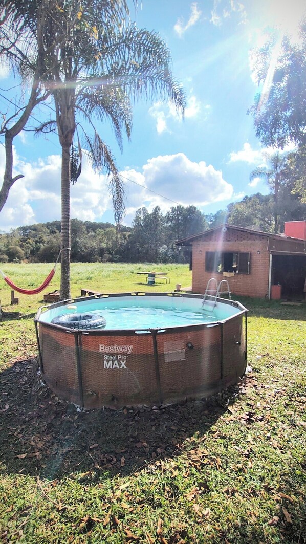 A backyard with a hot tub labeled 'Beastway Steel Pro MAX' and a hammock.