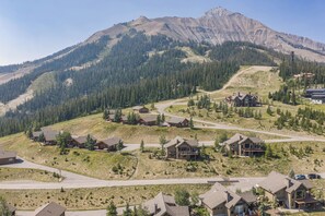 A residential area with multiple houses, roads, and a mountain backdrop.