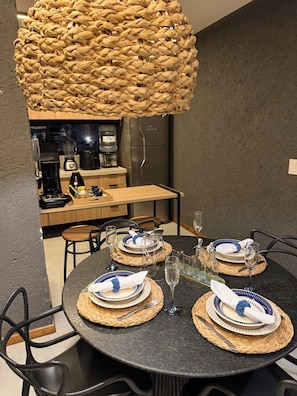 A dining area with a round table set for four, including plates, cutlery, and glasses.