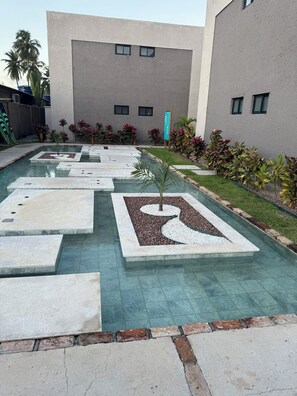 A modern outdoor pool area with geometric patterns and a clear blue pool.