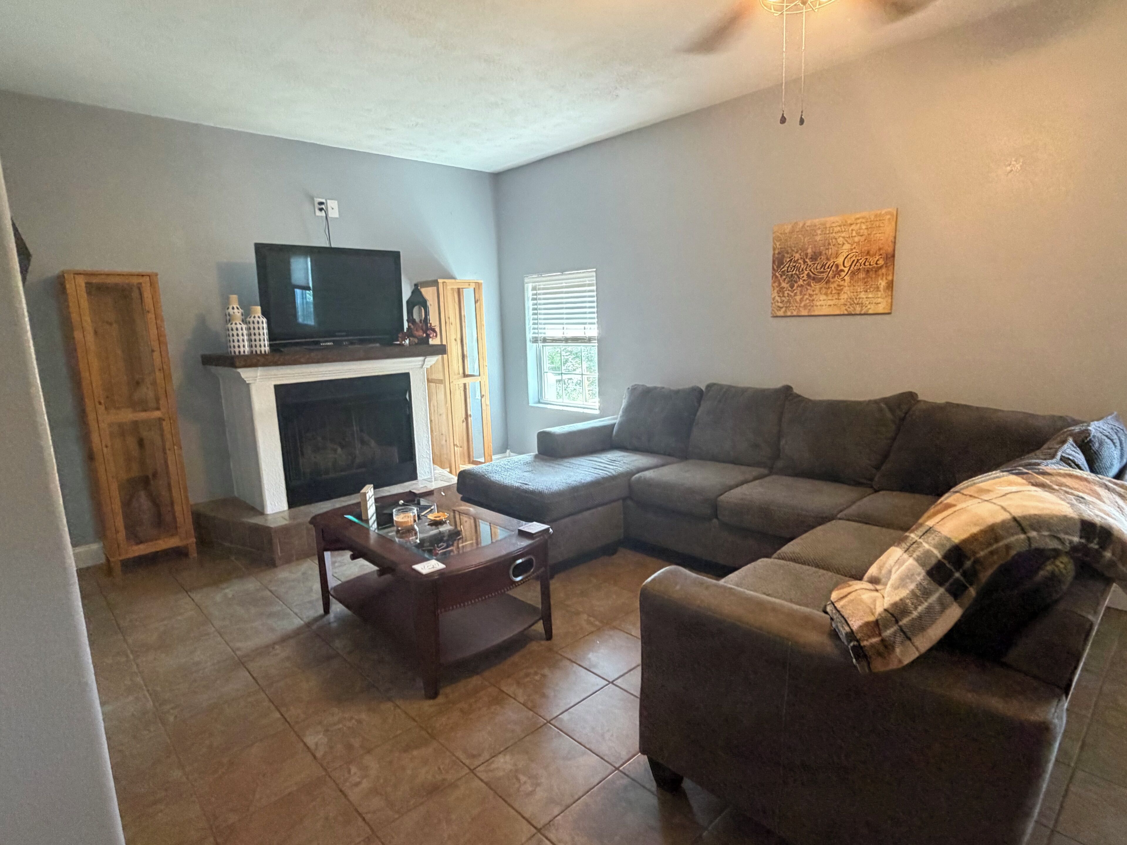 A living room with a fireplace, a television, a sofa, and a coffee table.