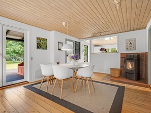 Un intérieur moderne comprenant un coin repas, une cheminée et des œuvres d’art accrochées aux murs.