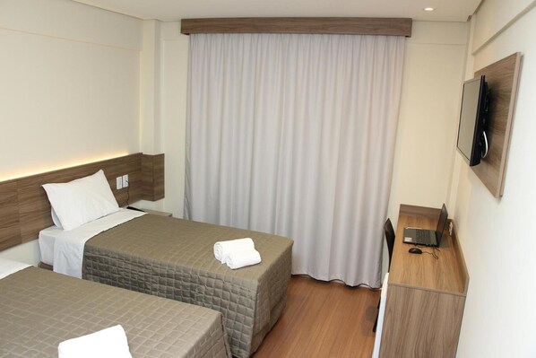 A hotel room with two beds, a desk, a TV, and a large window with curtains. - Convenient Room Near Praça Elza Carielo de Morais Laurenti – 1.2 Miles Away (Mato Grosso do Sul)