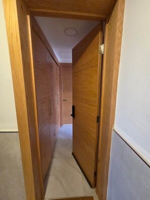 A narrow hallway with wooden doors on both sides, leading to a room. - Cozy Loft with Panoramic View in Chihuahua (Chihuahua)
