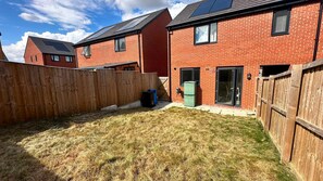 A residential area with brick houses, a wooden fence, and a grassy yard. - Sheffield Charm - Cozy 2 Bedroom House (Sheffield)