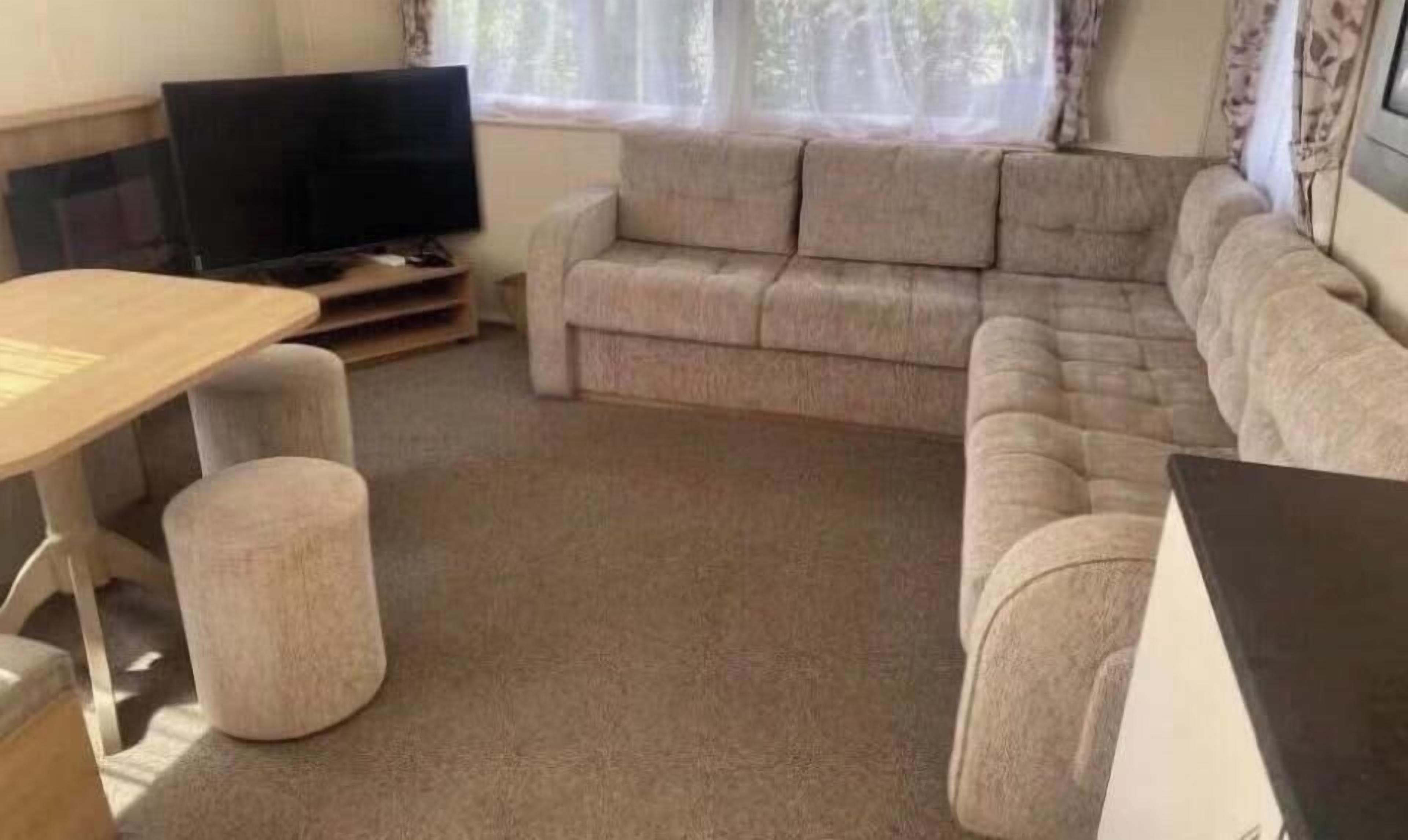A living room with a sofa, a television, and a table.