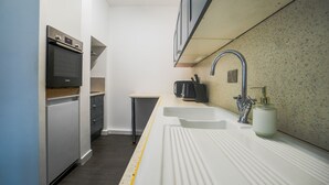 A compact kitchen with a built-in oven, a sink, and a small countertop. - Sleeps8-FamilyFriendly-4Bed-CentralSheffield (Sheffield)