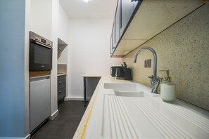 A compact kitchen with a built-in oven, a sink, and a small countertop. - Sleeps8-FamilyFriendly-4Bed-CentralSheffield (Sheffield)