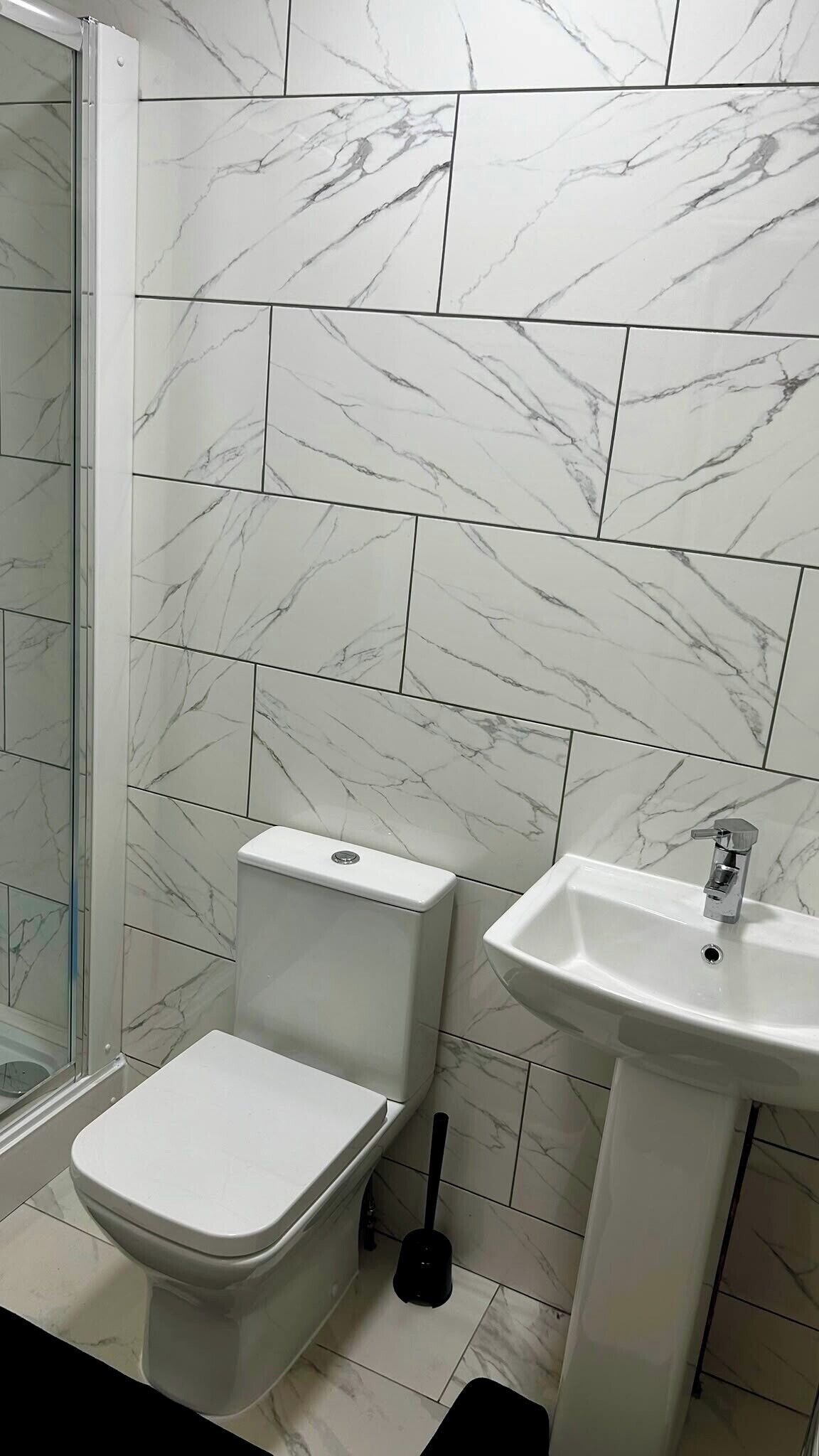 Un bagno con toilette, lavandino e zona doccia.