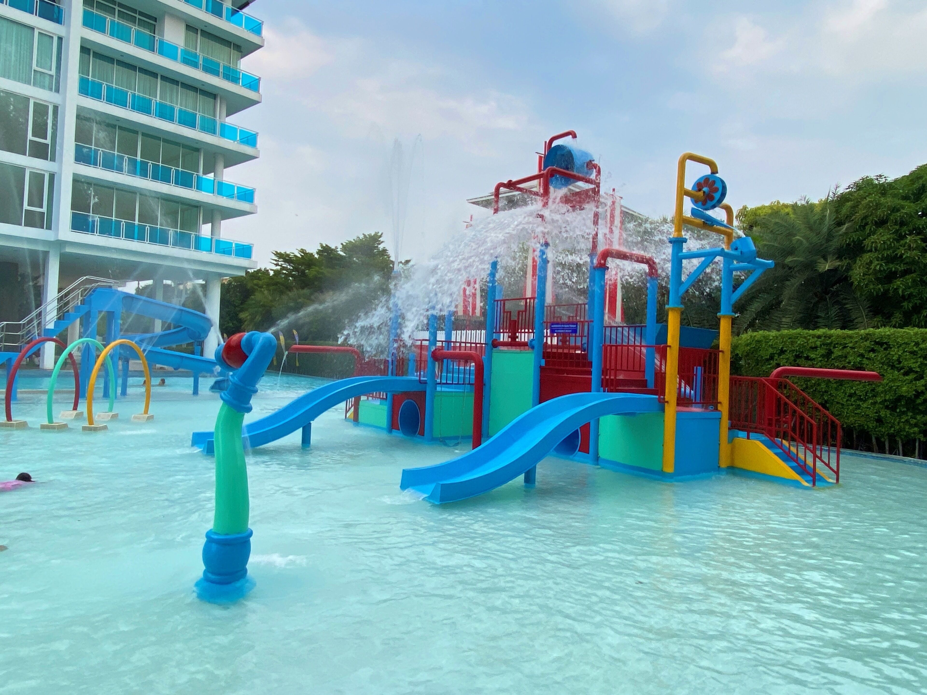 A water park with slides and a water fountain.