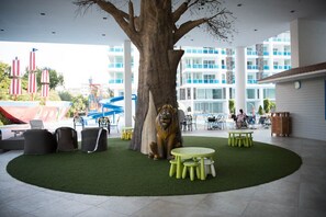 A courtyard with a large tree, outdoor seating, and a pool area. - A105 Cozy 2-bedroom apartment with AC in a pleasant location (Huahin)