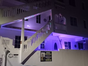 Ein mehrstöckiges Gebäude mit einer Treppe, Balkonen und einem Schild für den Mendez Royal Palace.