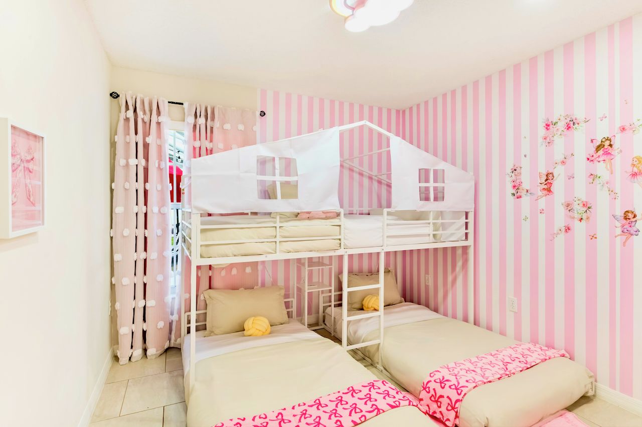 Une chambre avec des lits superposés, dotée d’un papier peint à rayures et d’un mur décoratif.