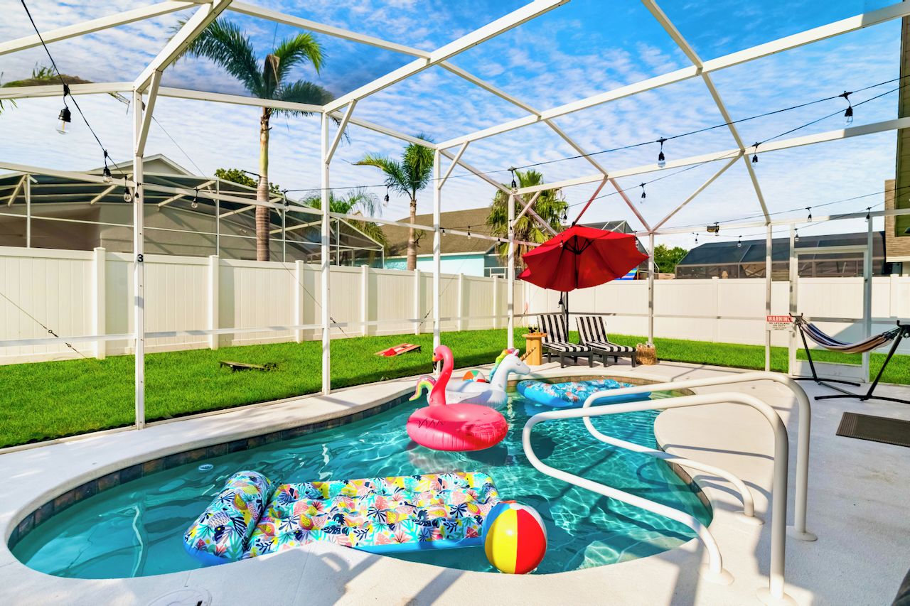 Ein Poolbereich mit Whirlpool, aufblasbaren Spielsachen und einer Hängematte.