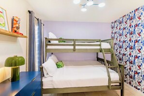 A bunk bed with a ladder, a bedside table with a lamp, and a wall with patterned wallpaper. - Luxury 4-bedroom house for family fun, Pool, 10 mins to Disney (Kissimmee)