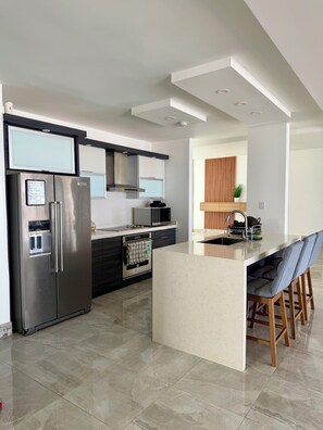 A modern kitchen with a stainless steel refrigerator, a built-in oven, and a microwave. - Casa Mar Ensueño/Luxury beachfront property with a pool. 5 minutes to the beach. (Tierras Nuevas Poniente)