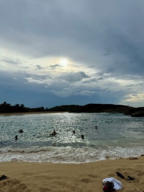 A beach with clear water, people swimming, and a sandy shore. - Casa Mar Ensueño/Luxury beachfront property with a pool. 5 minutes to the beach. (Tierras Nuevas Poniente)