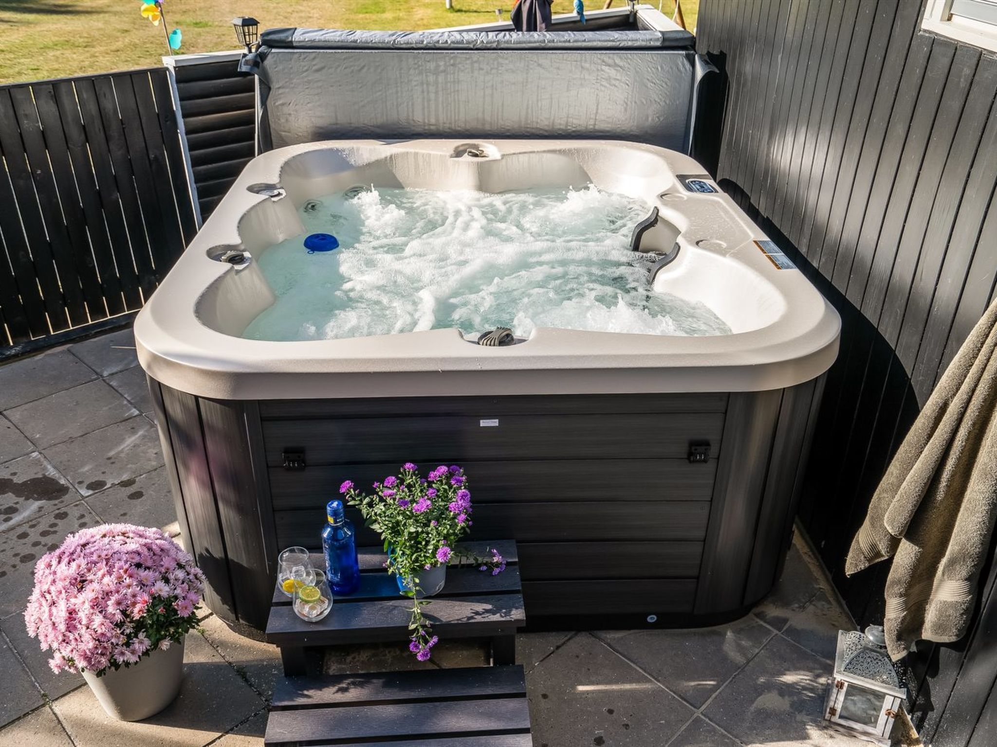 Un bain à remous doté d’une table et d’un banc intégrés, entouré d’une terrasse en bois.