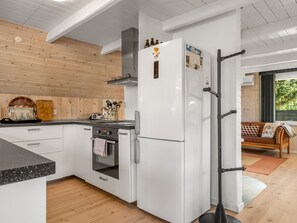 Eine moderne Küche mit weißen Schränken, einem eingebauten Backofen und einem großen Kühlschrank.