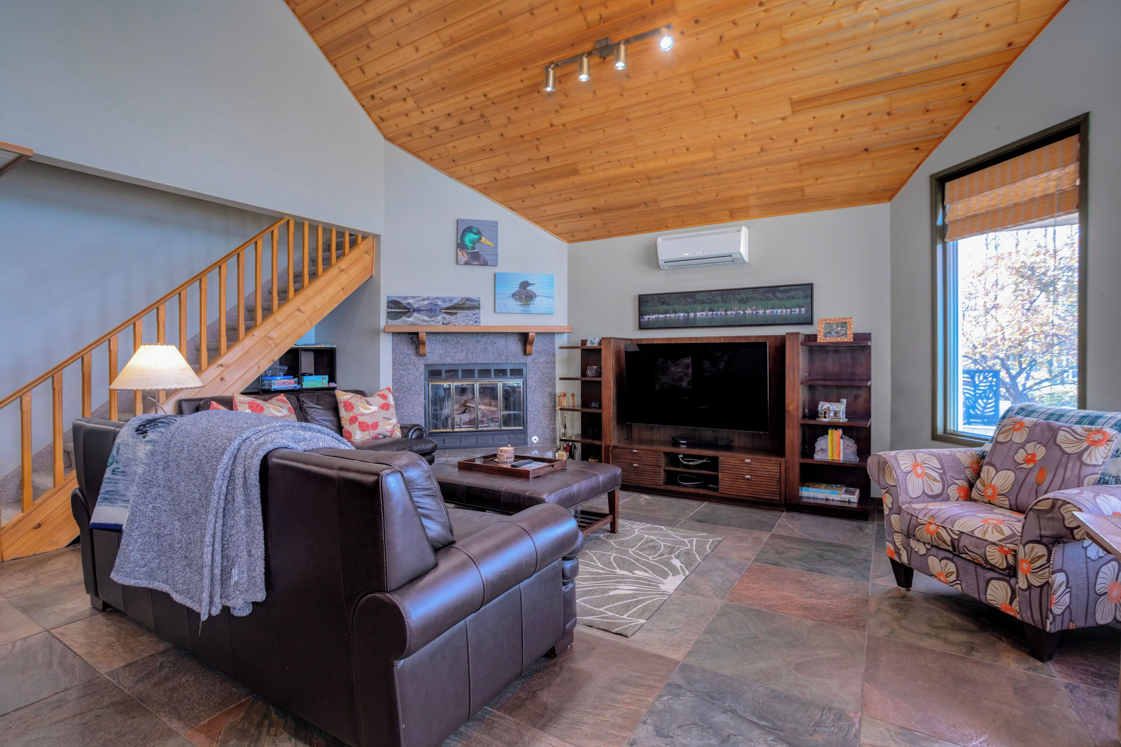 A spacious living room with a fireplace, a large flat-screen TV, and a comfortable seating area.
