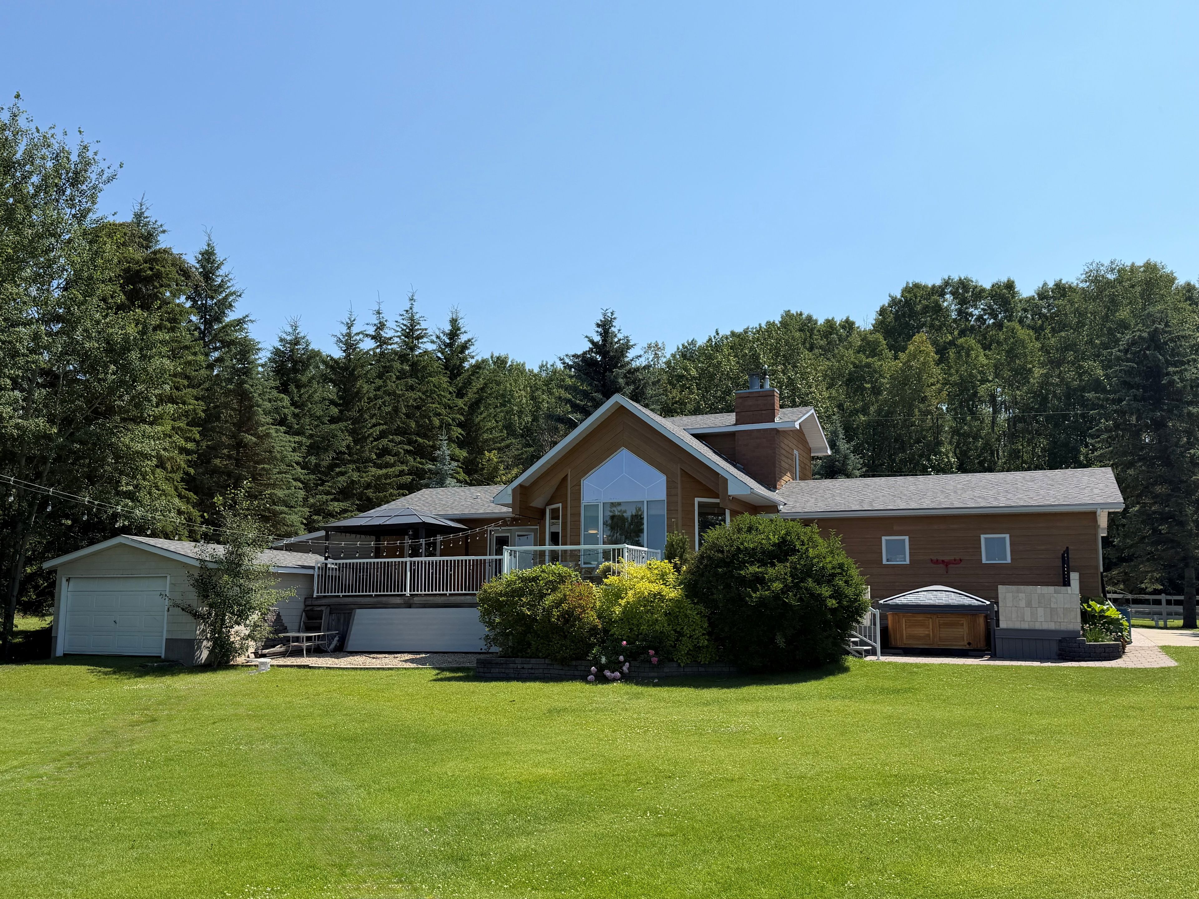 A two-story house with a large front porch, a garage, and a well-maintained lawn.