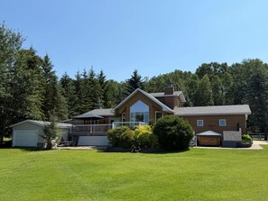 A two-story house with a large front porch, a garage, and a well-maintained lawn.