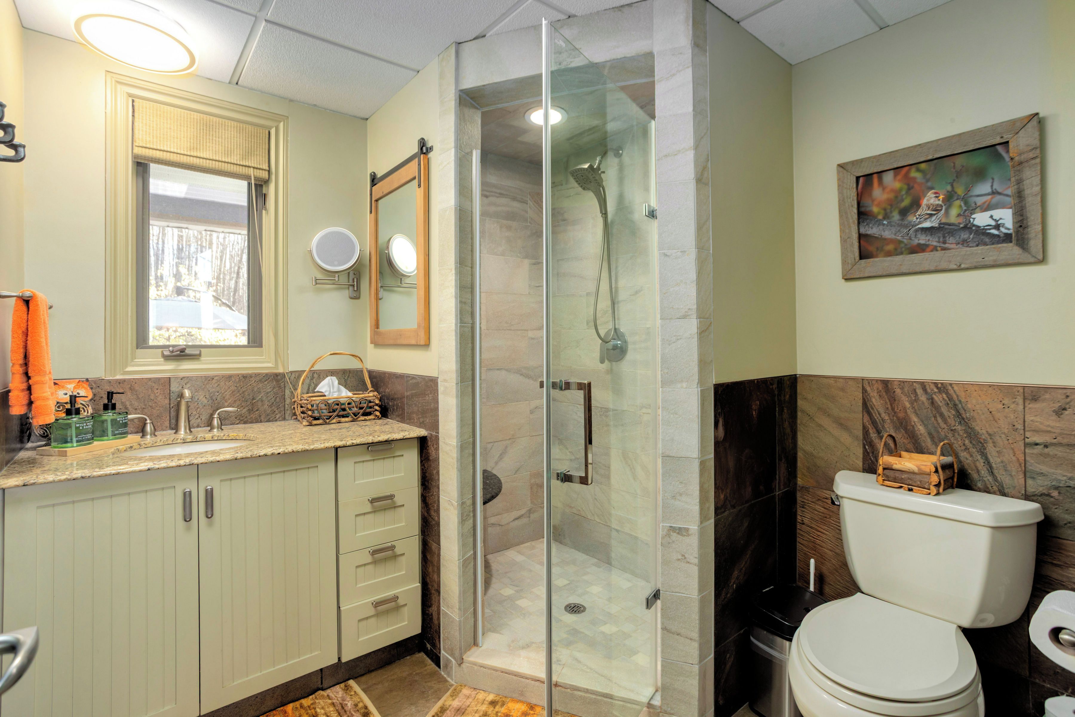 Une salle de bain avec douche, toilettes et lavabo.