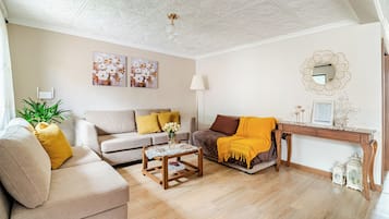 Ein Wohnzimmer mit einer Couch, einem Couchtisch, einer Lampe und einem dekorativen Spiegel.