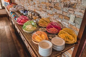 Een buffet met verschillende gerechten en bijbehorende sauzen.