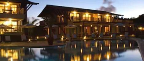 A hotel with a swimming pool and multiple buildings.