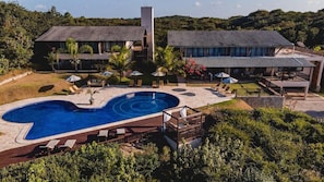 Un resort con piscina, poltrone a sdraio e un edificio a due piani.